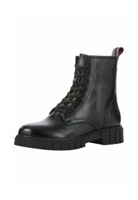Black leather ankle boot with rounded toe, lace-up front, and patterned rubber sole. Features a pull tab with red and blue stripes.