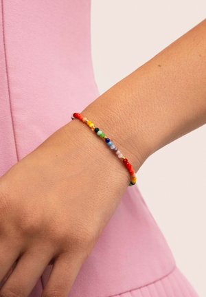 Bunte Perlenarmband mit kleinen runden Perlen in Rot, Gelb, Grün, Blau und Lila, auf einem elastischen Band aufgezogen.