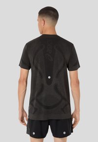 Dark gray short-sleeve athletic shirt featuring textured patterns, a circular accent on the back, and a fitted design.