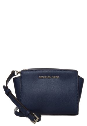 Donkerblauwe Michael Kors crossbody tas met verstelbare riem, goudkleurig logo en gestructureerde rechthoekige vorm.