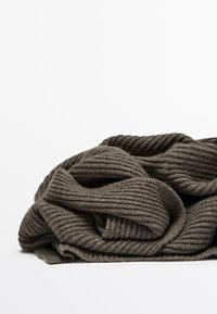 Scarf lavorato a maglia di colore grigio scuro, caratterizzato da una texture a coste e pieghe sovrapposte, progettato per calore e comfort. Materiale morbido con un aspetto voluminoso.