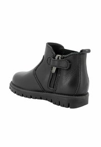 Stivale alla caviglia in pelle nera con zip laterale, tomaia tessurizzata, collare imbottito e suola robusta. Presenta un accento con fascetta in Velcro.