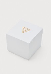 Witte vierkante doos met een getextureerd oppervlak, voorzien van een gouden driehoeklogo aan de bovenkant. De doos heeft een eenvoudig en strak ontwerp.