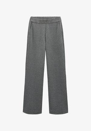 Wijduitlopende broek gemaakt van zwart-wit textiel, met een subtiel patroon, voorzakken en een elastische tailleband.