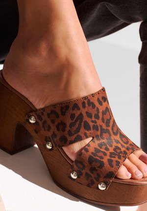 Brown leopard-print open-toe clogs with wooden heels and metallic studs. Features a cutout design and smooth leather finish.