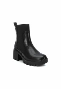 Botín negro hasta el tobillo con acabado de cuero suave, panel lateral elástico, tacón grueso y suela texturizada. Parte trasera reforzada para facilitar su uso.