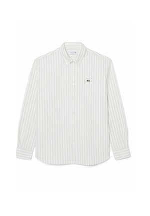 Camisa blanca de manga larga con rayas verticales gris claro y un pequeño logo de cocodrilo verde en el pecho izquierdo.