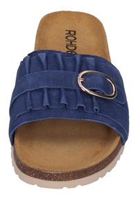 Blue slide sandal with ruffled strap, silver buckle detail, and beige rubber sole. Soft suede-like material with textured insole.