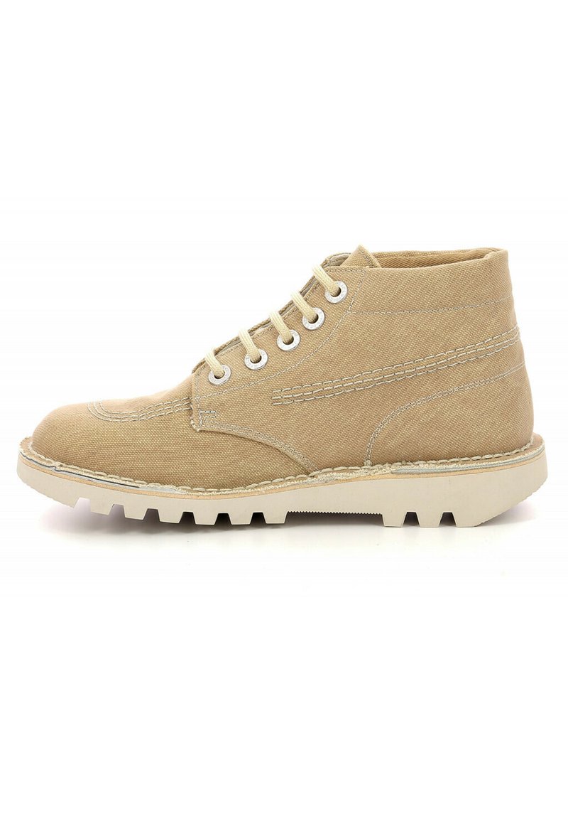 Botín de lona beige hasta el tobillo con costuras blancas, seis ojetes de metal, cordones beige y una suela gruesa blanca y robusta.