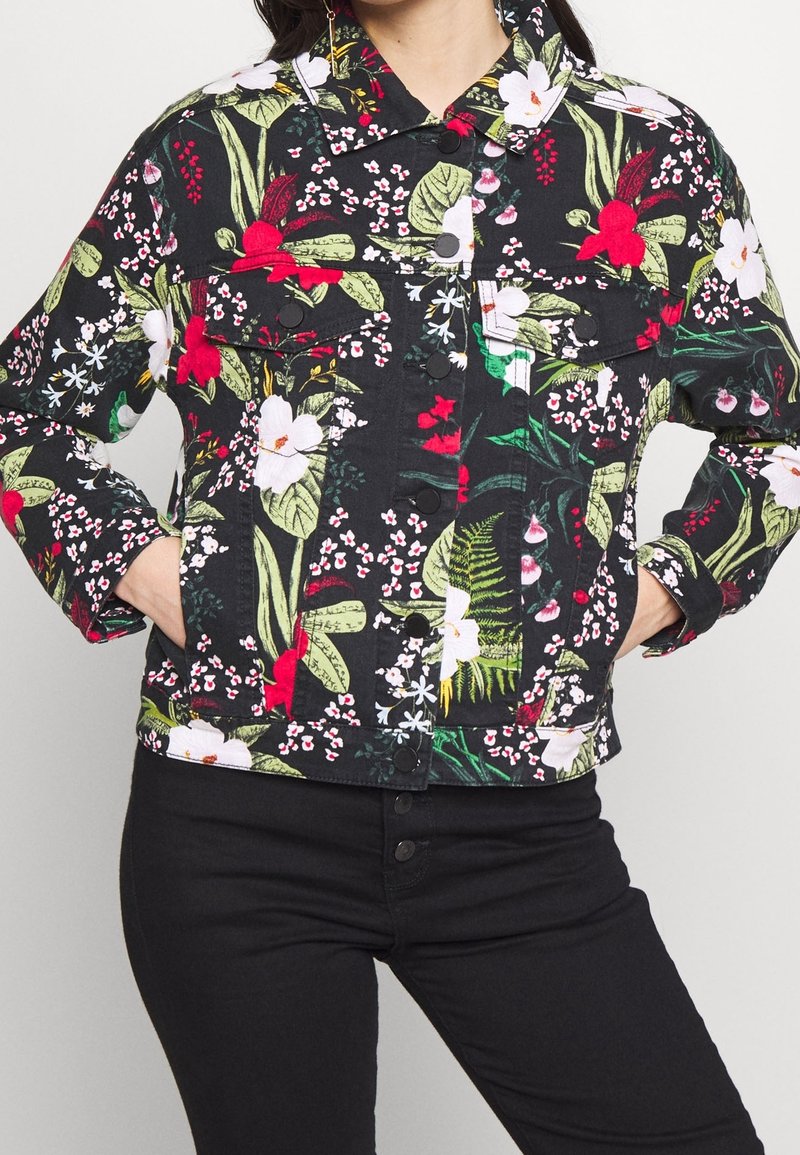 Giacca di jeans con design floreale su base nera, caratterizzata da fiori rossi e bianchi, foglie verdi, tasche frontali e chiusura a bottoni a pressione.