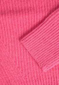 Pink knitted fabric with a ribbed texture, featuring a soft, fuzzy appearance. The material is thick and warm with visible stitch patterns.