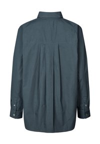 Košile na knoflíky z tmavě petrolejové látky, s záševkem na zádech, dlouhými rukávy a manžetami na knoflíky. Hladká textura s klasickým límečkem.