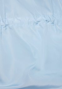 Helleblaue, glatte, synthetische Stoff mit einem subtilen Glanz. Verfügt über geraffte Nähte für Textur und eine leichte Elastizität im Design.