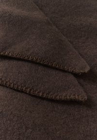 Mørkebrun uld plaid med en blød, tekstureret overflade og kontrasterende syede kantdetaljer. Foldet med spidse hjørner synlige.