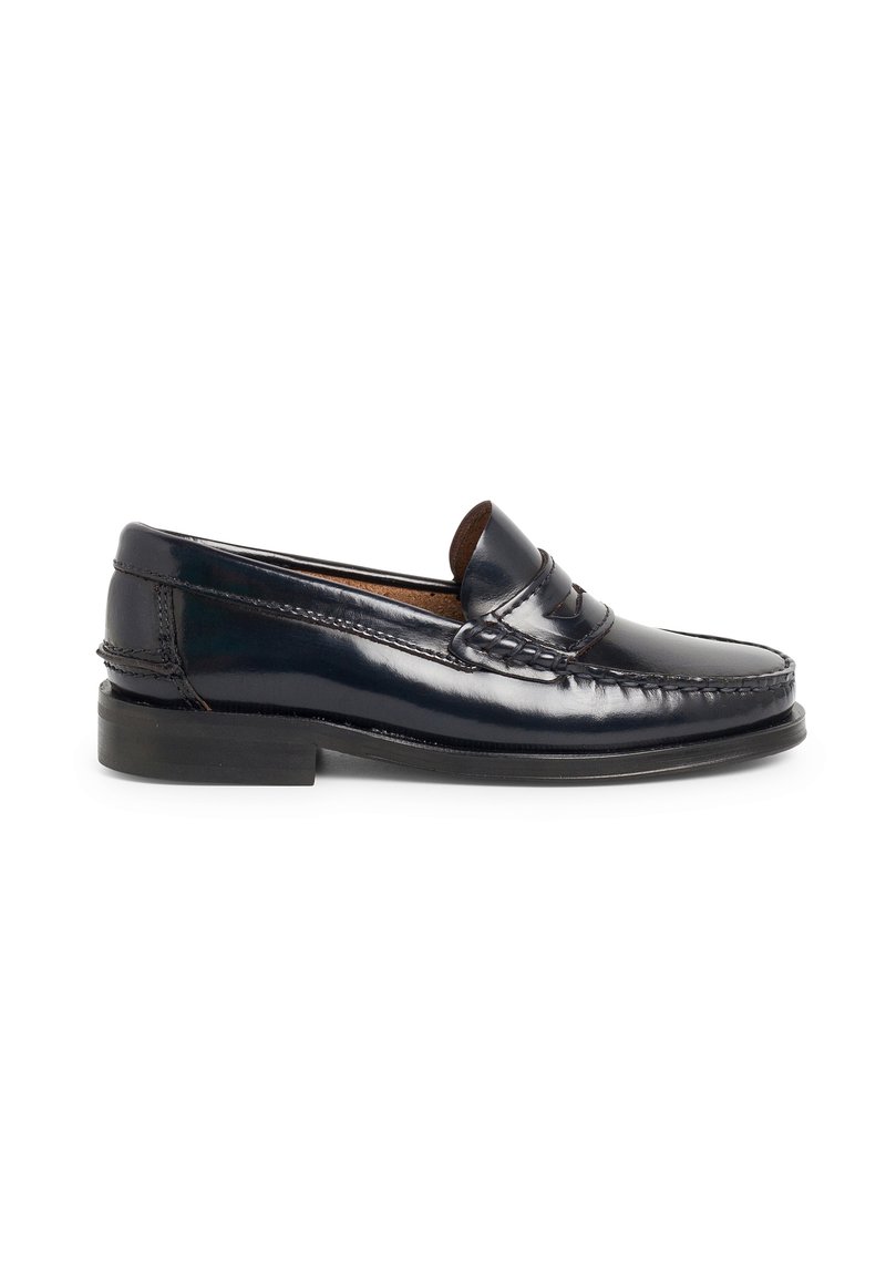 Mocasin de cuero azul marino con diseño cosido, punta redondeada y tacón bajo. Textura suave con una correa decorativa a lo largo del empeine.