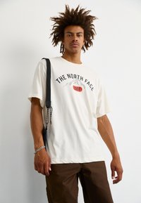 The North Face M VARSITY GRAPHIC RELAXED SS TEE - Triko s potiskem - white dune