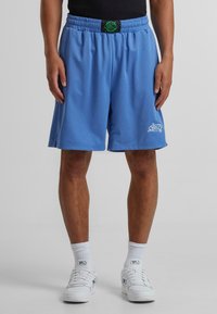 Světlé modré síťované basketballové �šortky s elastickým pasem a zelenou visačkou s logem. Bílý detail loga na dolní levé nohavici.