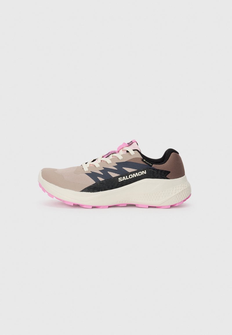 Beige and pink Salomon running shoe with black logo and design accents, cream midsole, and pink outsole, viewed from the side on a plain background.