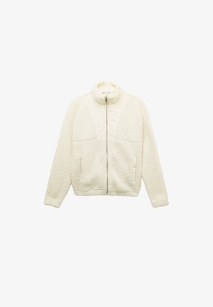 Kremowa polarowa kurtka z półgolfem, przednim zamkiem błyskawicznym, dwiema kieszeniami po bokach oraz teksturowanym materiałem. Gładkie akcenty z materiału na ramionach.
