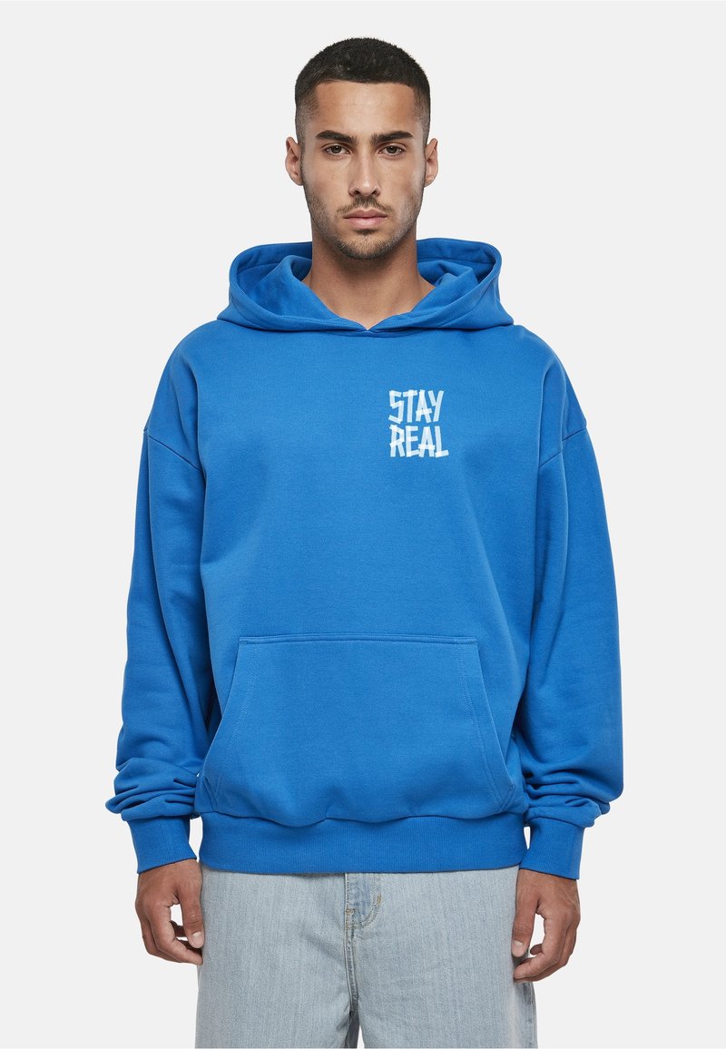 Felpa con cappuccio blu con tasca frontale, con una grafica bianca "STAY REAL". Realizzata in materiale morbido, con vestibilità ampia e cappuccio regolabile.