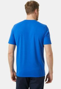 Camiseta azul de manga corta con cuello redondo, hecha de un tejido suave. Presenta un diseño simple y sólido, sin estampados ni adornos.