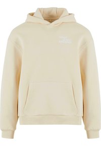 Cremefarvet hoodie med en kengurulomme, snor i hætten og "WHAT goes AROUND" trykt i hvid på brystet. Blød stofstruktur.