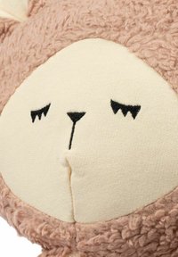 Mehek plišasta igračka s rožnato rožnato teksturo na zunanji površini, obrazom v kremni barvi iz bombaža in vezenimi črnimi obraznimi značilnostmi.
