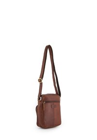 Braune Leder-Crossbody-Tasche mit verstellbarem Tragegurt, rechtem Reißverschluss, glatter Textur und markantem Logoanhänger an der Seite. Kompakte rechteckige Form.