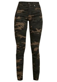 Jean camouflage coupe slim en tons verts foncés et bruns, avec cinq poches, une braguette zippée et un tissu texturé.