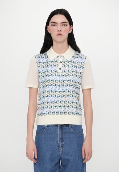 Polo à manches courtes avec un motif tricoté en vagues et accents teal, col crème et boutons sur le devant.