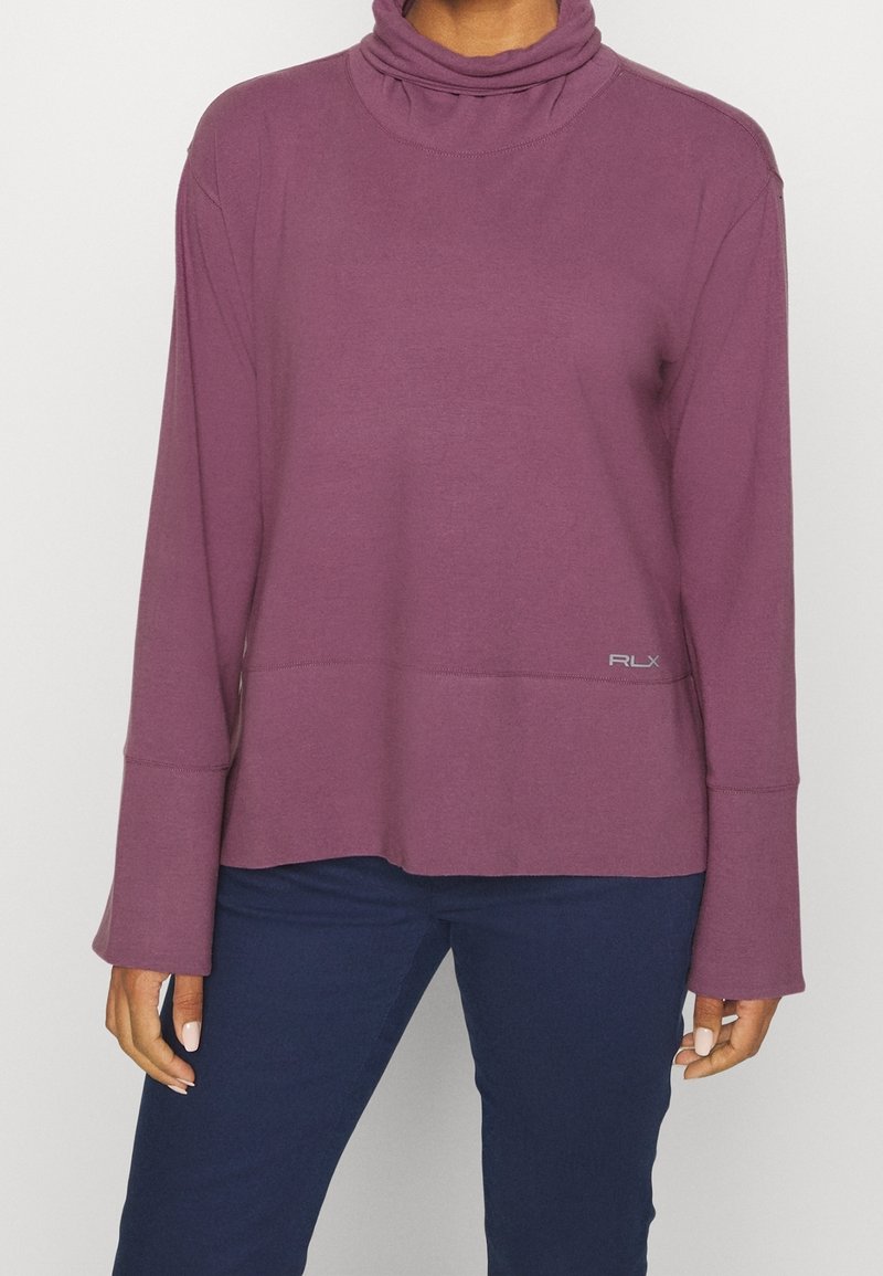 Weinrotes Langarmoberteil mit einem Schalkragen, tailliertem Design und kontrastierendem Logo-Detail unten rechts. Weiches, strukturiertes Material.