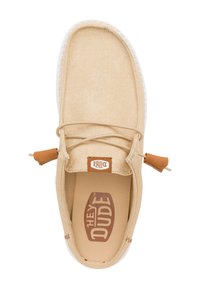 Sneaker in tela beige con punta arrotondata, lacci sottili e un accento in pelle marrone chiaro. Suola bianca con interni testurizzati e marchio sulla soletta.