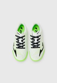 Scarpe da ginnastica bianche con lacci neri e logo. Presentano una parte superiore testurizzata, suola verde lime e accenti di contrasto sui lati.