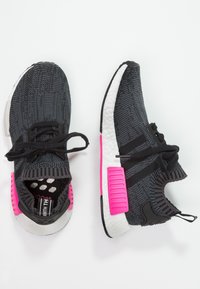 Svarta och grå stickade sneakers med rosa accenter, strukturerad överdel, rund tå, svarta snören och vita vadderade sulor.