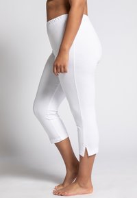 Leggings capri bianchi con vita elasticizzata e spacchi laterali all'orlo. Realizzati in un tessuto morbido e liscio.