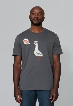 Grijze t-shirt met korte mouwen met een cartoon meeuw graphic en een spreukballon "MOIN!" in oranje en wit. Zachte katoenen stof.