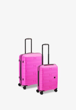 Zwei Hartschalenkoffer in leuchtendem Pink, mit einem strukturierten Design und horizontalen Rillen, schwarzen Rollen und ausziehbaren Griffen.