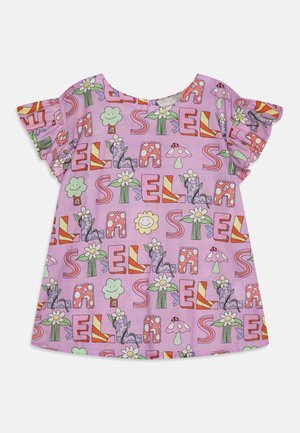 Blusa curta roxa de mangas curtas, com padrões divertidos de letras, flores e rostos sorridentes em várias cores. Tecido suave com mangas com franzido.