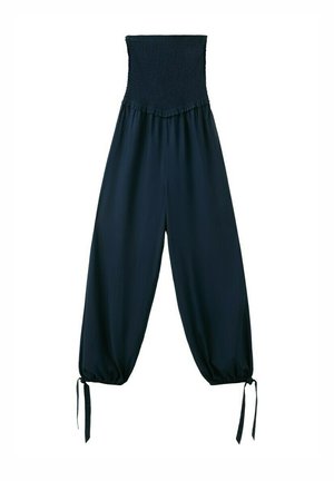 Pantalones negros de pierna ancha de talle alto con cintura elástica fruncida y cordones atados en los bajos de los tobillos sobre fondo blanco.