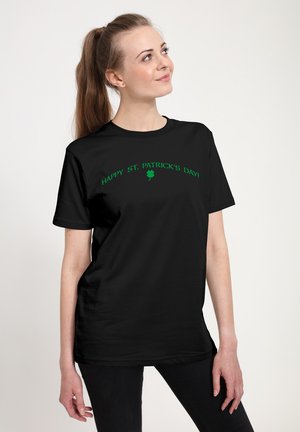Zwarte t-shirt met korte mouwen met groene tekst "HAPPY ST. PATRICK'S DAY!" en een groene klavergrafiek. Glad katoenstof.