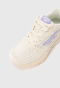 Cream-colored sneaker featuring mesh and suede materials, a rounded toe, and light lavender accents on the side and tongue.