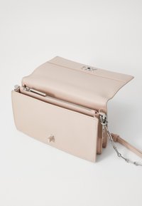 Borsa a mano in pelle rosa chiaro con logo argentato, scomparto con zip e tracolla a catena. Presenta una forma rettangolare e una texture liscia.