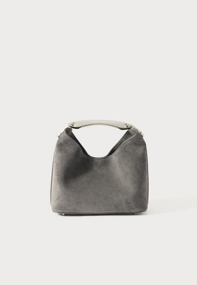 Bolso de ante gris con una silueta curva, que presenta un asa metálica que complementa la suave textura y diseño.