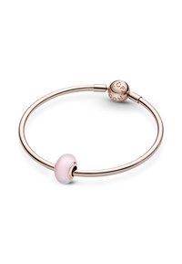 Bracciale in oro rosa con un charm in vetro rosa lucido, dotato di un moschettone rotondo in oro inciso con "Pandora". Design semplice e circolare.