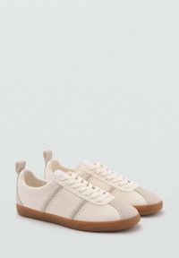 Sneaker in tela crema con accenti beige, dotate di punta rotonda, design con lacci e suola in gomma. Retro chiuso con linguetta per il tallone.