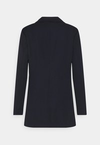 Veste marine à col cranté, manches longues et coupe ajustée. Tissu lisse sans motifs visibles, avec une fente centrale au dos.