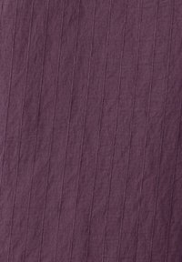 Tissu violet profond avec de fines lignes verticales cousues créant une texture côtelée sur la surface.