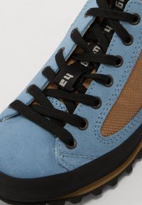 Hellblaue Wildlederschuhe mit schwarzen Schnürsenkeln, braunen Mesh-Akzenten, Gummisohle und verstärkter Zehenpartie. Besitzt haltbare Nähte und eine strukturierte Oberfläche.