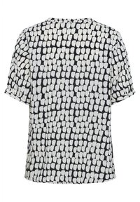T-shirt à manches courtes en bleu marine foncé avec un motif abstrait blanc. Tissu doux, forme ample et col rond. Présente des manches retroussées.