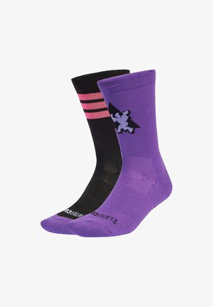 Lila och svarta strumpor; en har rosa ränder och en lejon-grafik. Materialet verkar slätt; måttlig höjd med ribbade manschetter.
